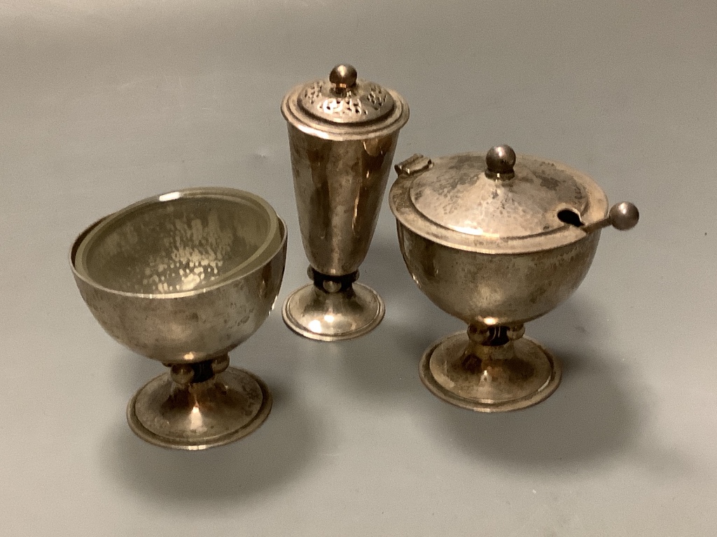 A stylish Art Deco planished silver three piece condiment set and matching spoon, by Charles Boyton, London, 1936/7 & 8, tallest piece 9cm, 9oz.